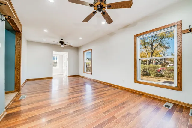 a view of an empty room with window and wooden floor