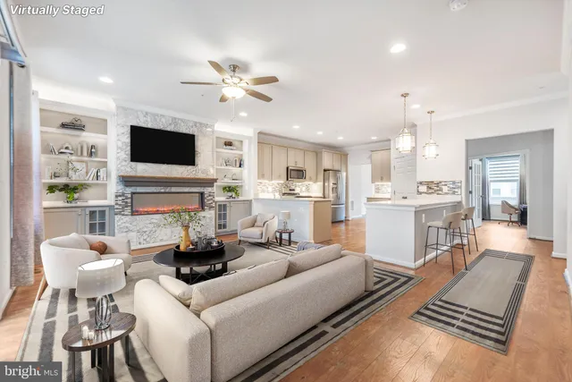 a living room with furniture a flat screen tv and kitchen view