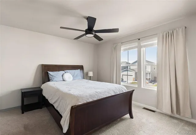 a large bed sitting in a bedroom next to a window