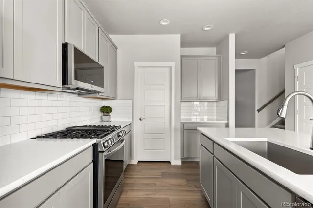 a kitchen with stainless steel appliances granite countertop a sink stove and refrigerator