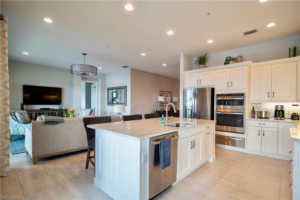 8008 Signature Club Circle Naples, FL 34113 - Photo 14 of 30 a large white kitchen with a stove a sink a microwave and a refrigerator