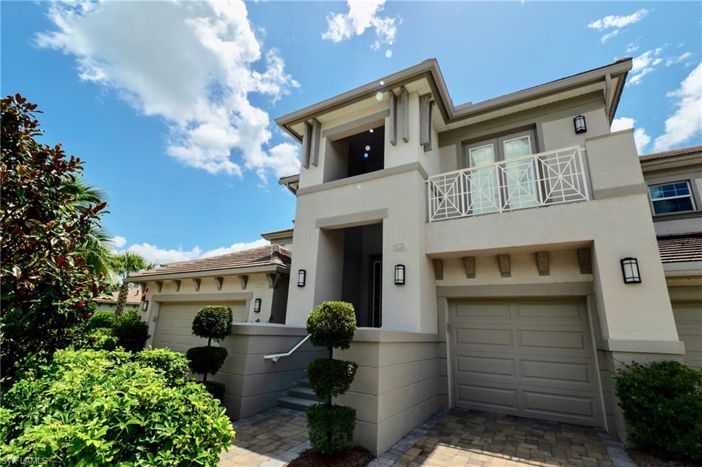 8008 Signature Club Circle Naples, FL 34113 - Photo 4 of 30 a front view of a house with a garden