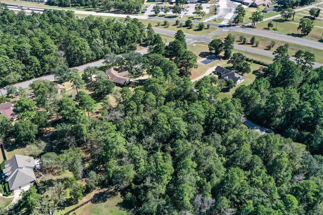 an aerial view of residential house with outdoor space and trees all around