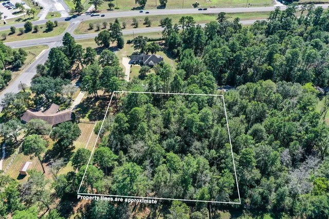 an aerial view of a house with a yard and lake view