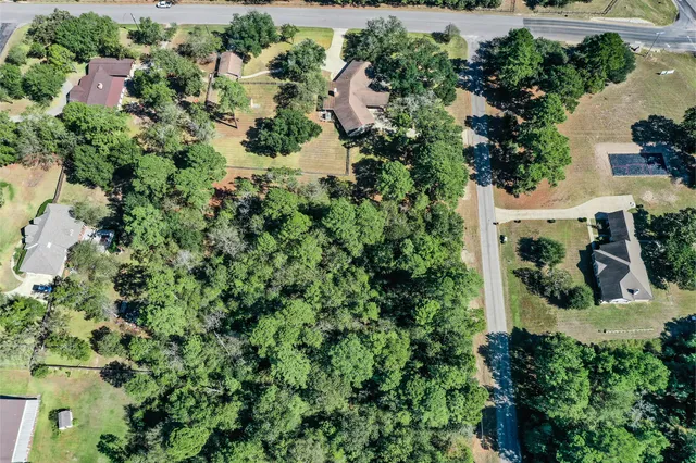 an aerial view of residential house with outdoor space and trees all around