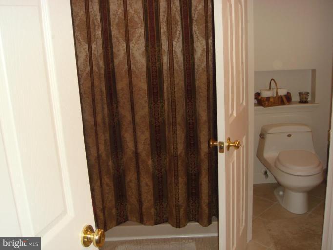 311 Whitaker Mill Road Fallston, MD 21047 - Photo 8 of 28 a bathroom with a toilet and a shower curtain