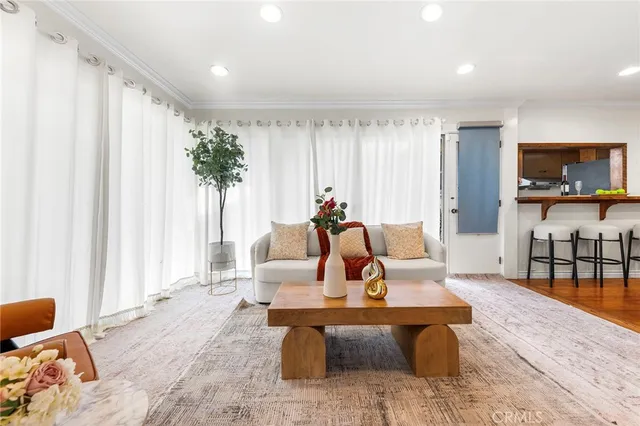 a living room with furniture a flat screen tv and a large window