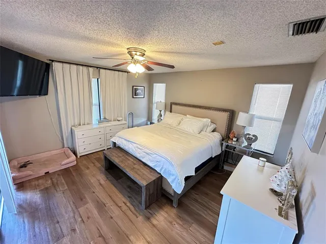 a bedroom with a bed window and wooden floor