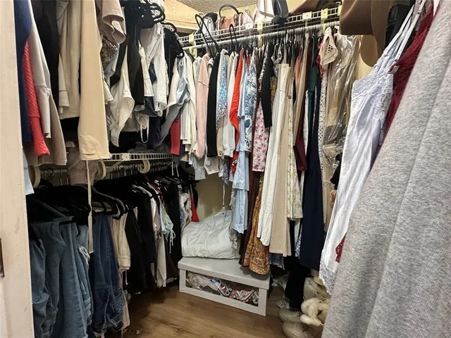 a view of walk in closet with clothes