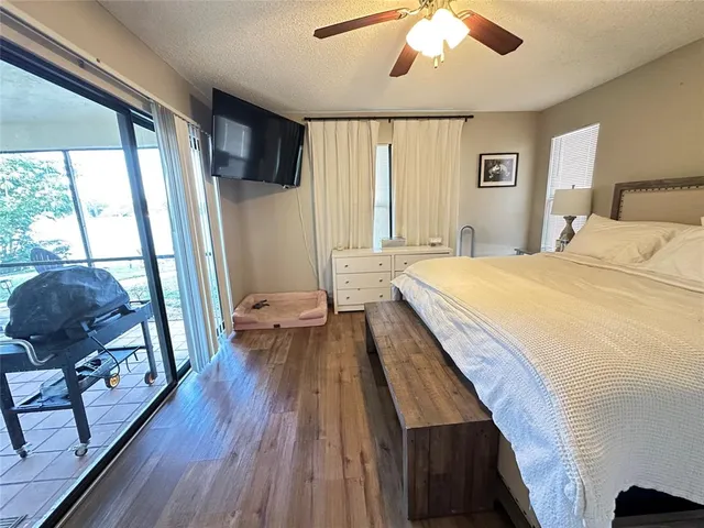 a spacious bedroom with a bed and wooden floor