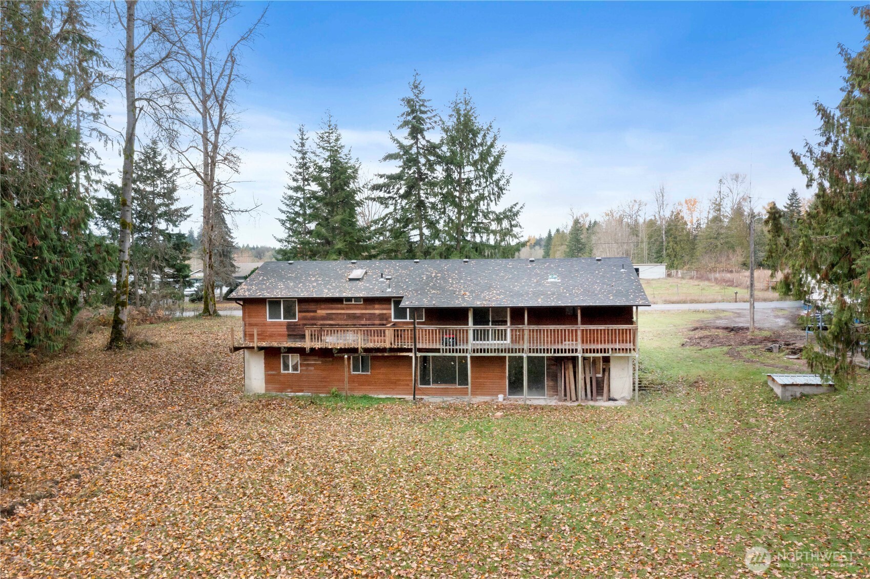 29621 Webster Road East Graham, WA 98338 - Photo 25 of 35 a backyard of a house with large trees and wooden fence