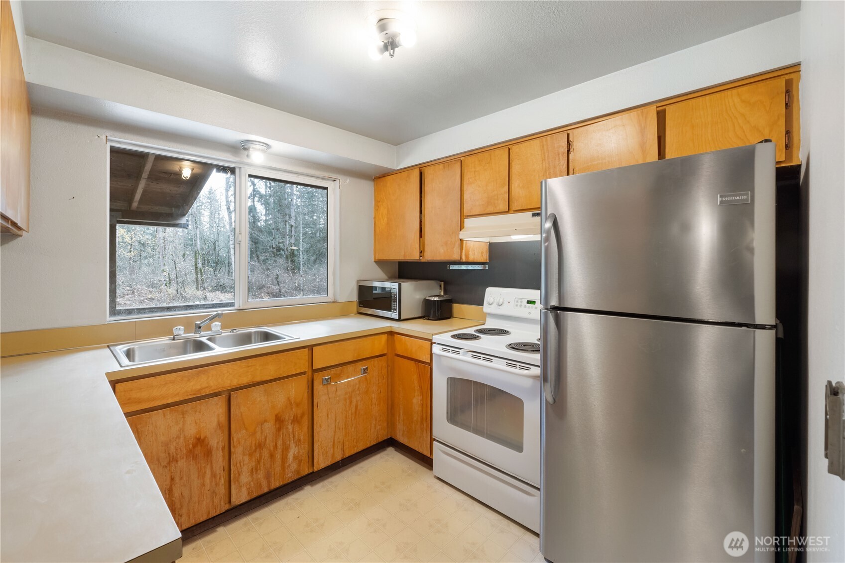 29621 Webster Road East Graham, WA 98338 - Photo 9 of 35 a kitchen with stainless steel appliances a refrigerator sink and cabinets