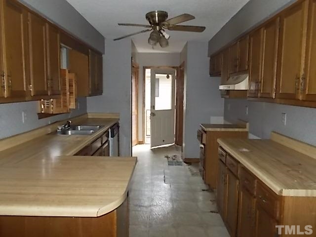 831 Horton Road Durham, NC 27704 - Photo 4 of 8 a kitchen with a sink a stove and a refrigerator