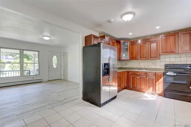 a kitchen with stainless steel appliances granite countertop a refrigerator and a stove top oven