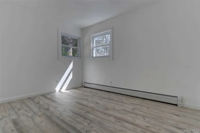a view of a big room with wooden floor and windows