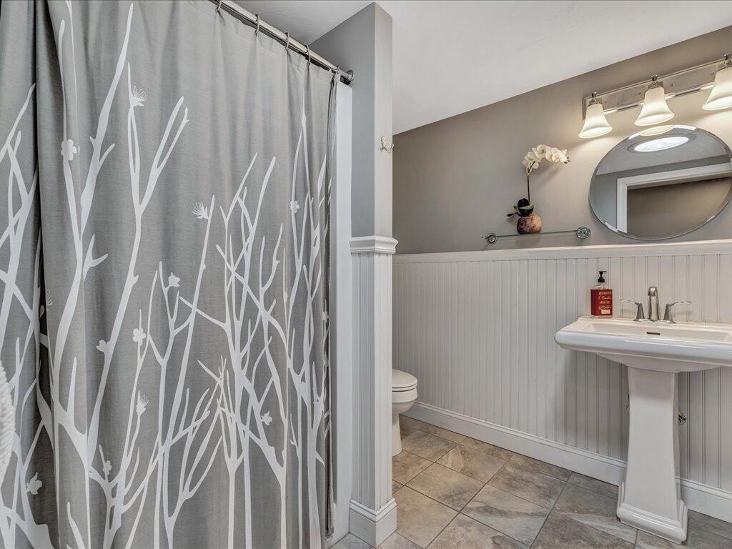 1309 Shootflying Hill Road Centerville, MA 02632 - Photo 30 of 52 a bathroom with a sink a toilet and mirror