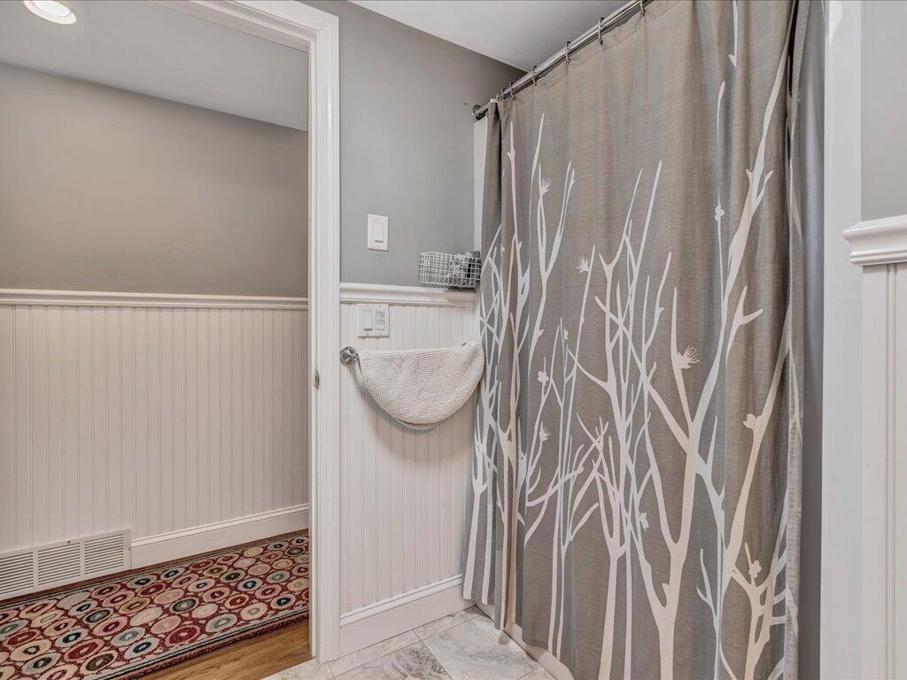 1309 Shootflying Hill Road Centerville, MA 02632 - Photo 31 of 52 a bathroom with a shower curtain and a sink