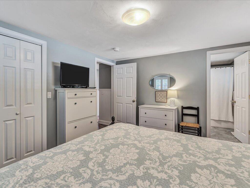 1309 Shootflying Hill Road Centerville, MA 02632 - Photo 34 of 52 a bedroom with a bed and a flat screen tv in white cabinet