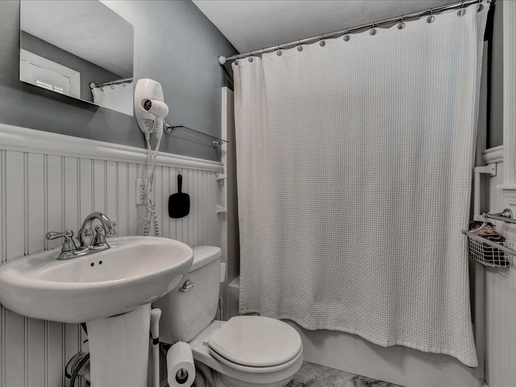 1309 Shootflying Hill Road Centerville, MA 02632 - Photo 36 of 52 a bathroom with a sink a toilet a mirror and shower curtain