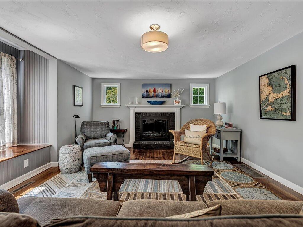 1309 Shootflying Hill Road Centerville, MA 02632 - Photo 6 of 52 a living room with furniture and a fireplace