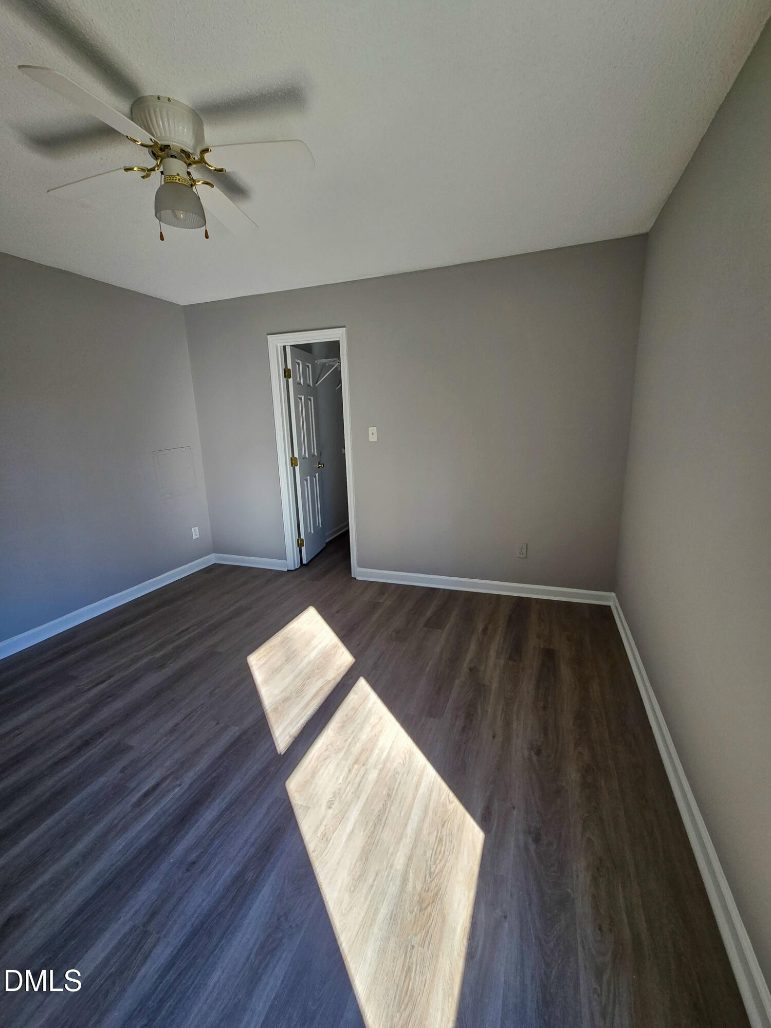 2205 Dungiven Court Garner, NC 27529 - Photo 47 of 66 an empty room with wooden floor a ceiling fan and windows