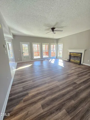 wooden floor fireplace and windows in an empty room