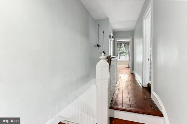 a view of a hallway with wooden floor and staircase