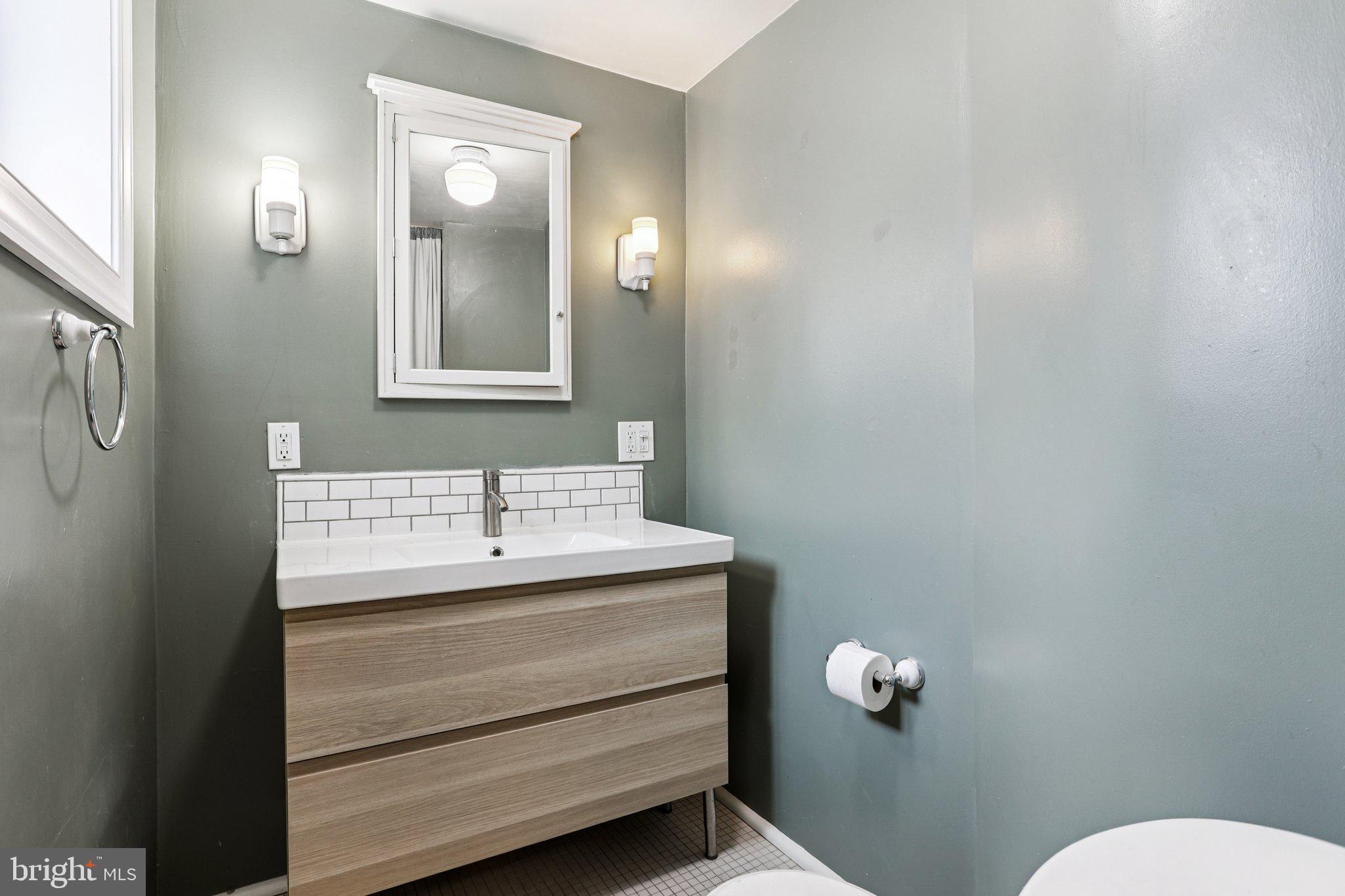2335 Christian Street Philadelphia, PA 19146 - Photo 18 of 33 a bathroom with a sink a toilet and mirror