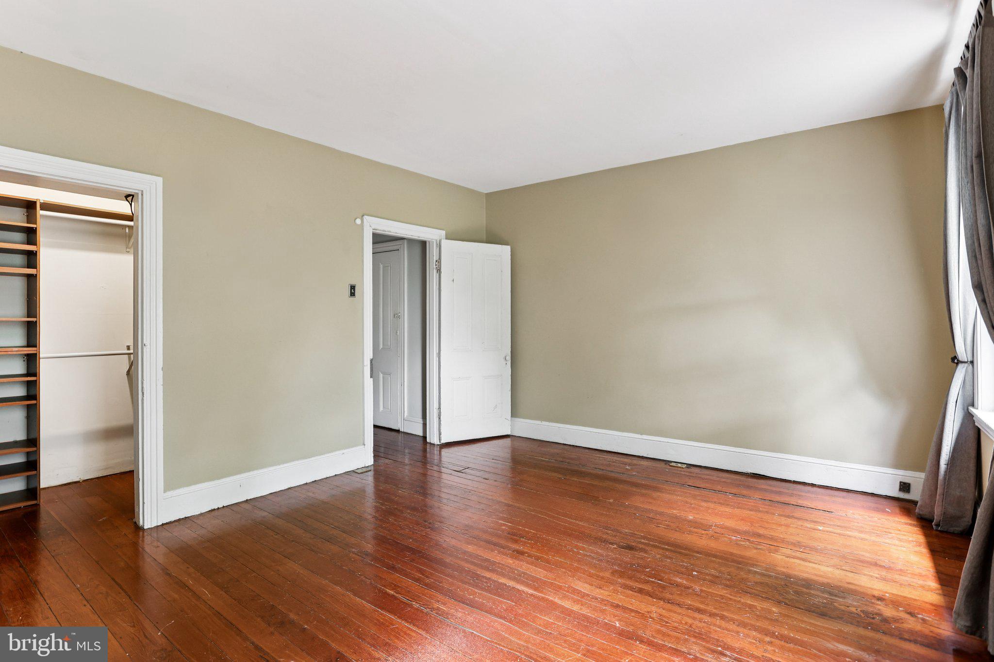 2335 Christian Street Philadelphia, PA 19146 - Photo 22 of 33 a view of an empty room with wooden floor and a window