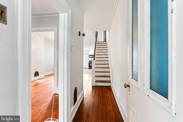 a view of a hallway with wooden floor and staircase
