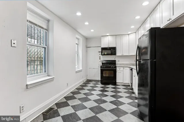 a kitchen with granite countertop a refrigerator and a sink