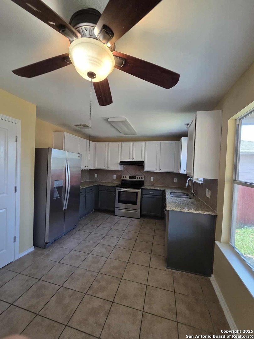 228 Anvil Place Cibolo, TX 78108 - Photo 6 of 21 a kitchen with stainless steel appliances granite countertop a sink and a refrigerator