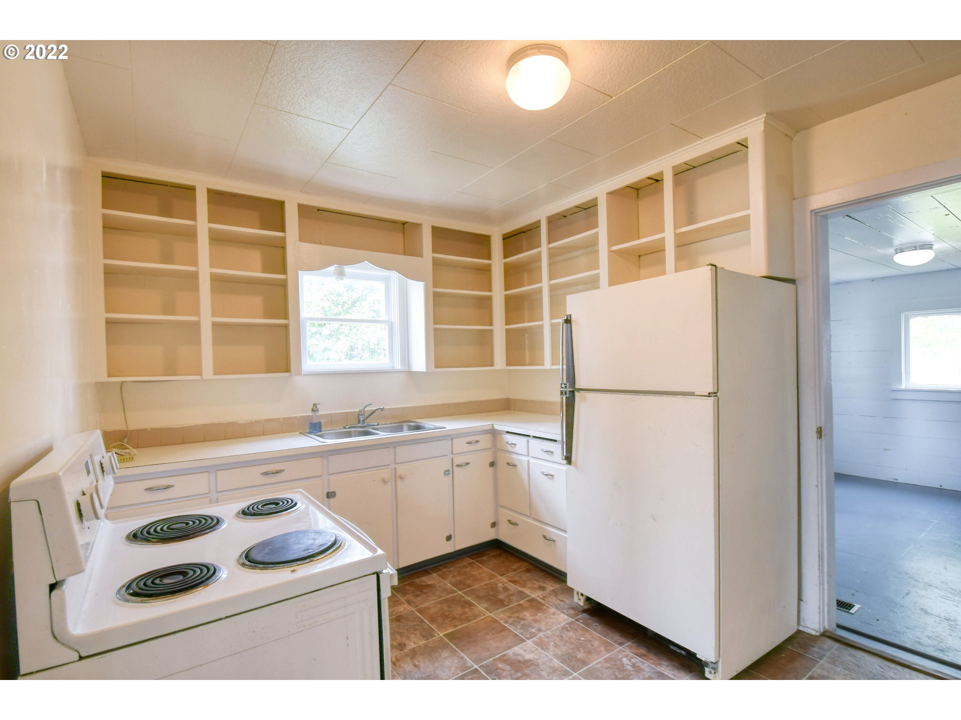 211 West Arch Street Union, OR 97883 - Photo 7 of 32 a kitchen with a sink a stove a refrigerator and white cabinets