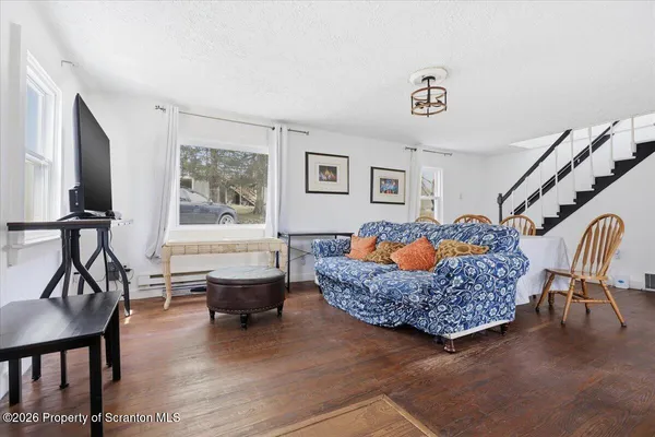 a living room with furniture a flat screen tv and a window