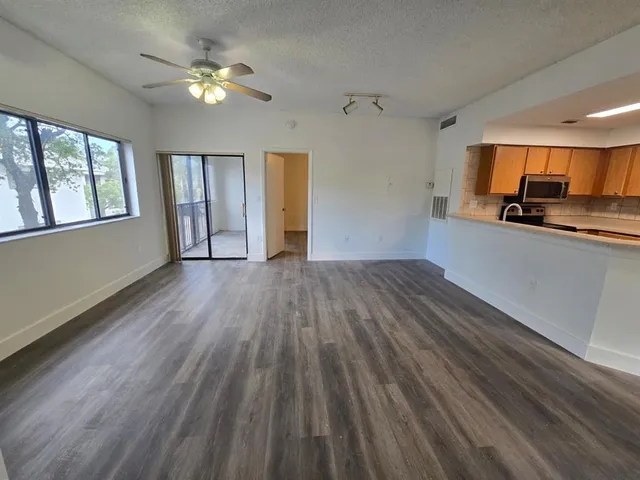 a view of a kitchen with wooden floor and a window