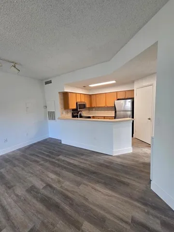 a view of a kitchen with wooden floor and a sink
