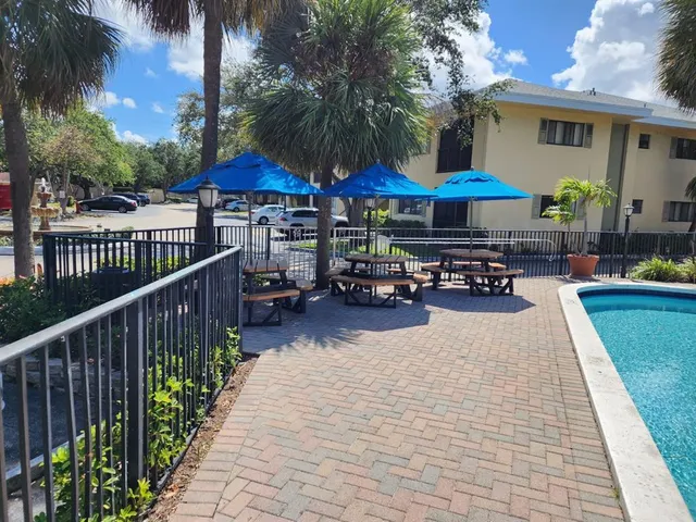 a patio with a table and chairs under an umbrella