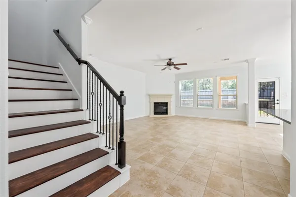 a view of an empty room with wooden floor and a fireplace