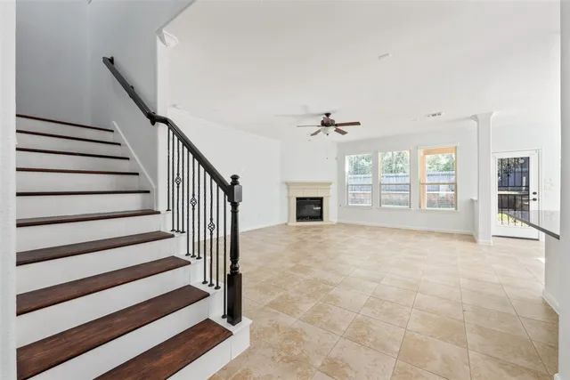 a view of an empty room with wooden floor and a fireplace