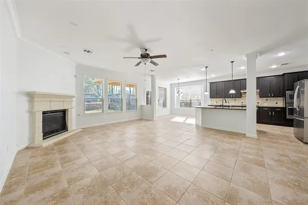 a view of a kitchen with kitchen island wooden floor and a ceiling fan