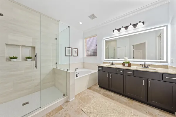 a spacious bathroom with a tub sink shower and mirror