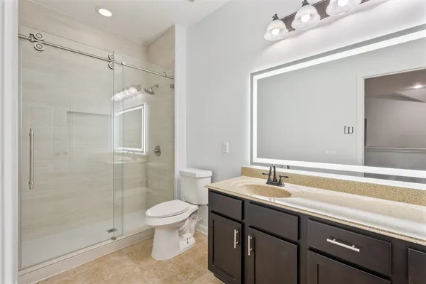 a bathroom with a sink a toilet and shower