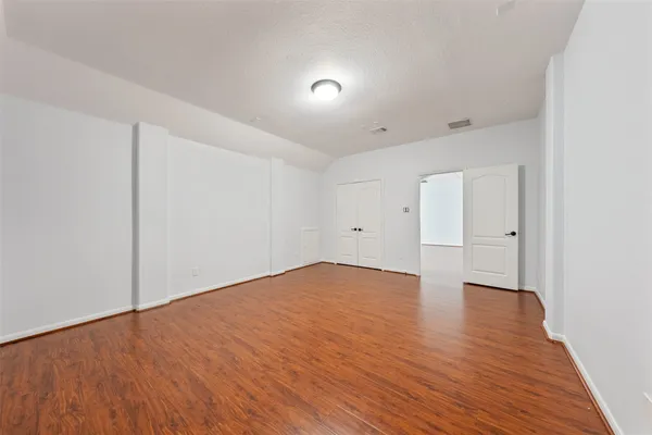 a view of empty room with wooden floor