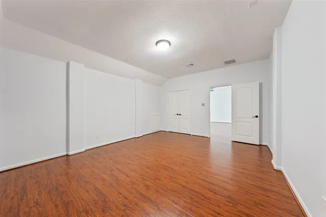 a view of empty room with wooden floor