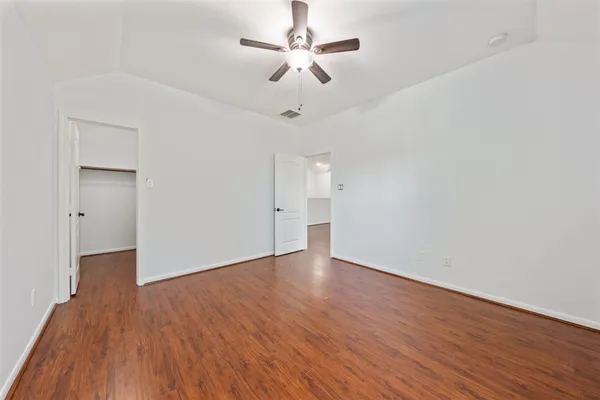 a view of an empty room with wooden floor