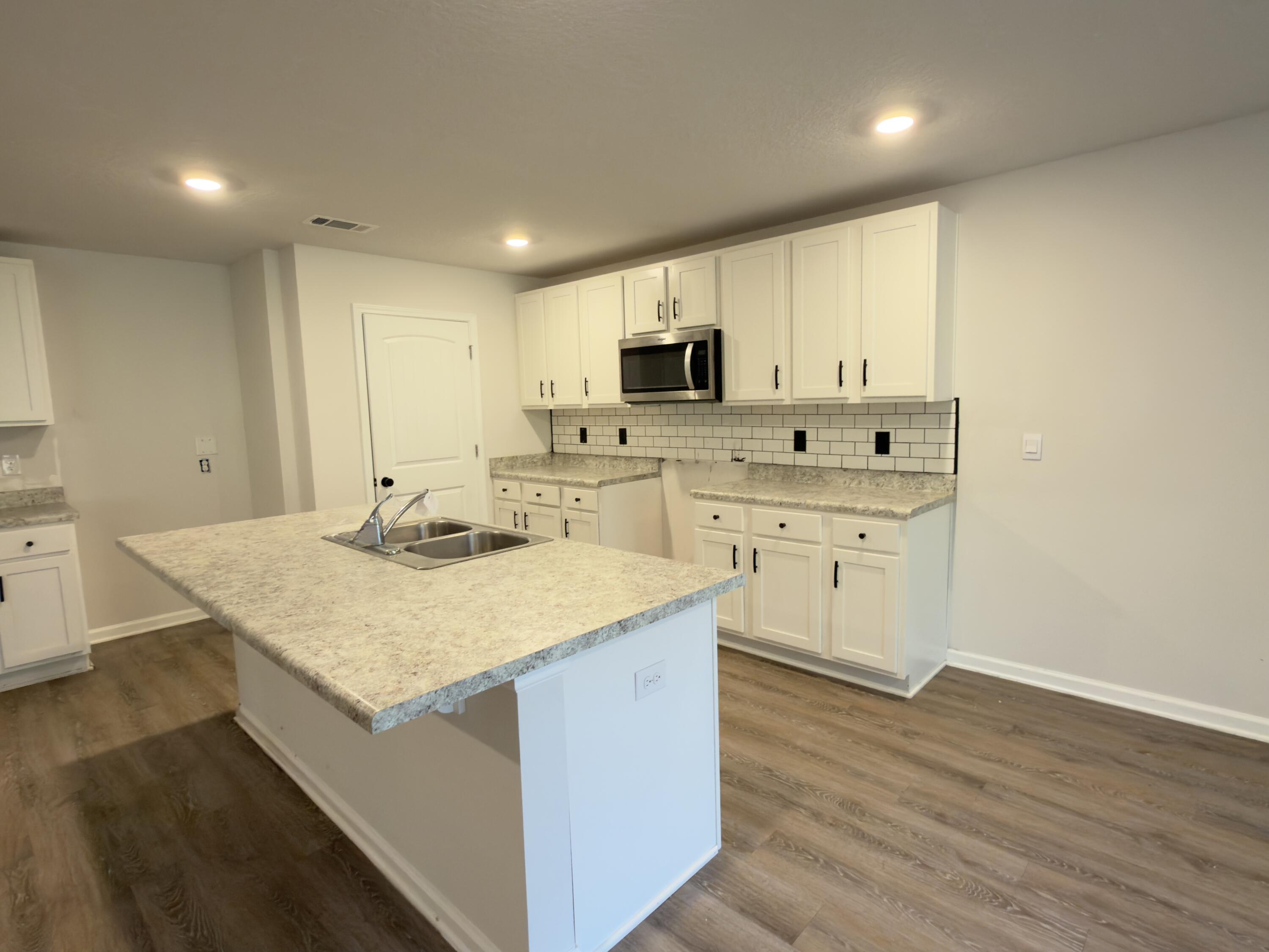 3545 Sugar Maple Lane Crestview, FL 32539 - Photo 7 of 27 a kitchen with a sink stove and cabinets