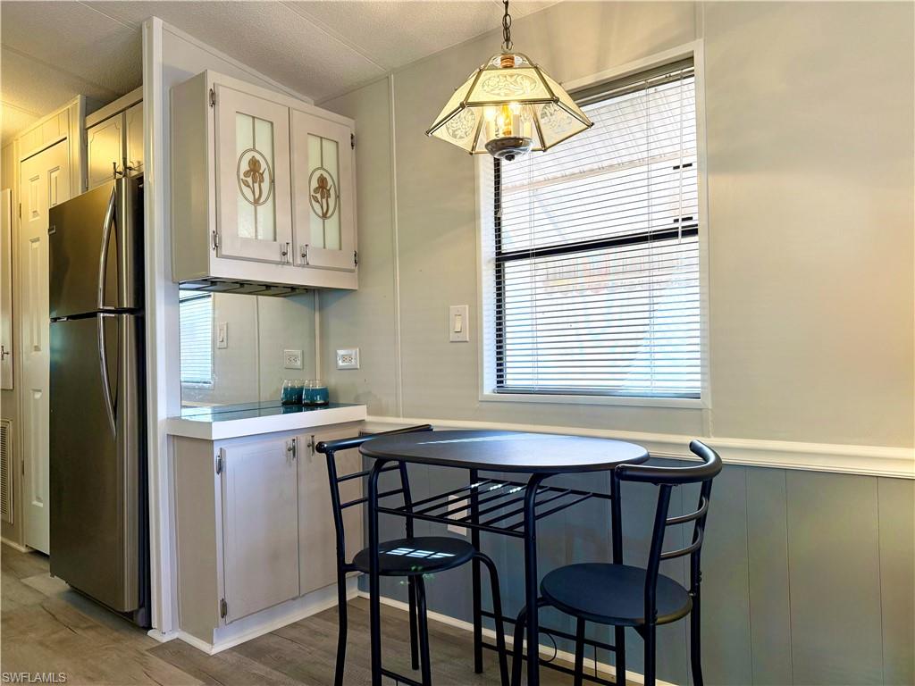16 Bass Lane, Unit 16 Naples, FL 34114 - Photo 19 of 45 a kitchen with stainless steel appliances granite countertop a dining table chairs and a refrigerator