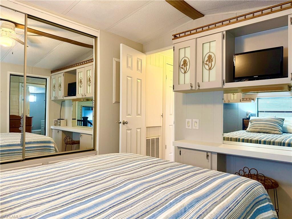 16 Bass Lane, Unit 16 Naples, FL 34114 - Photo 22 of 45 a bedroom with a bed and a flat screen tv