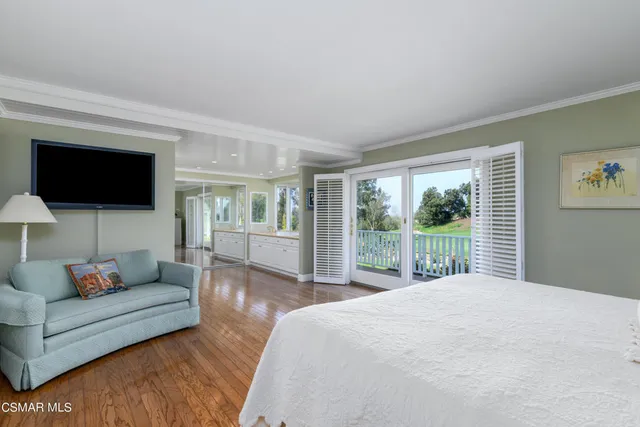 a living room with furniture a flat screen tv and a large window