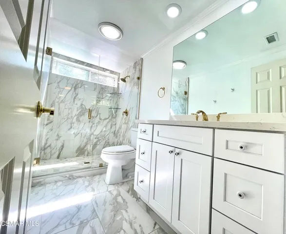 a bathroom with a double vanity sink toilet and shower